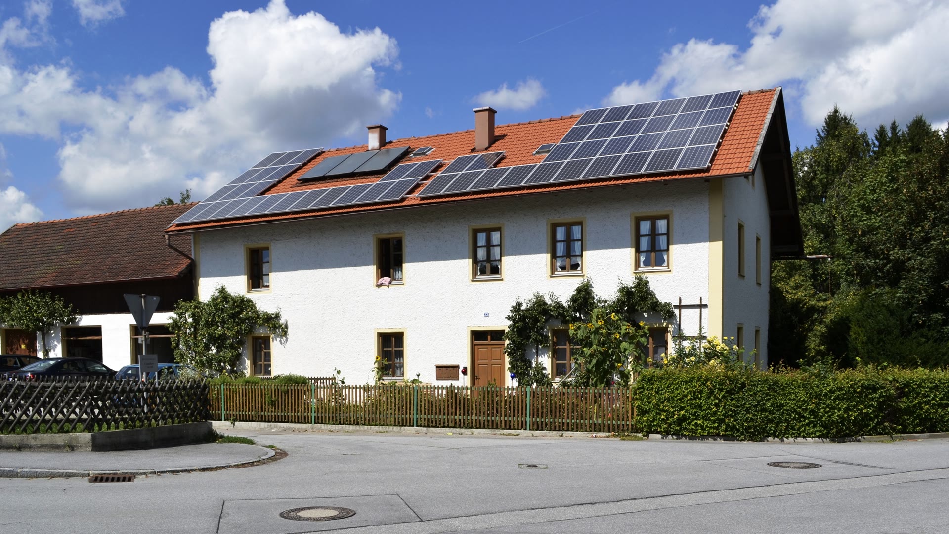 Wohnhaus in Vilshofen an der Donau mit Photovoltaikmodulen und Solarthermie auf einem roten Ziegeldach.